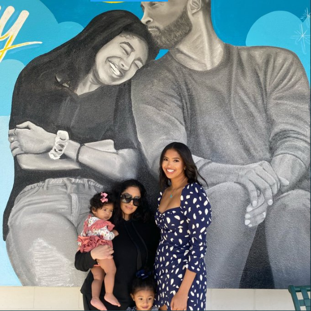 Vanessa Bryant and her daughters pose next to a mural of Kobe and Gigi Bryant