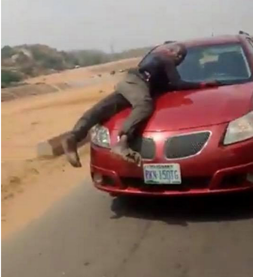 (Video) Policeman spotted on bonnet of speeding vehicle of lady who refused to stop for security operatives who were not wearing face masks (video) 1
